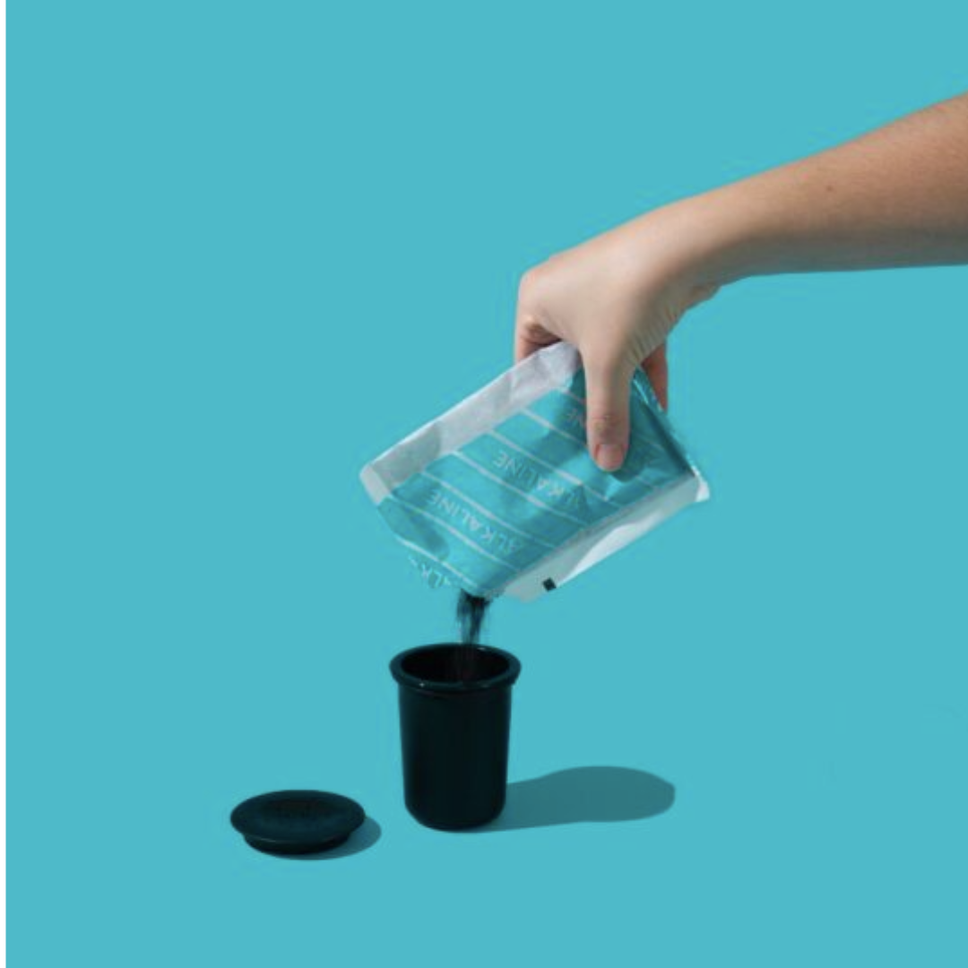Hand pouring Phox refillable granules into reusable water filter cartridge  