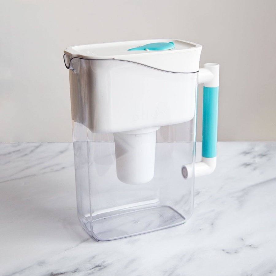 White fridge friendly sustainable water filter jug with blue handle on marble surface 